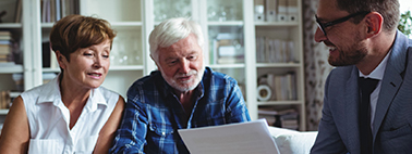 A financial professional smiles as he works with a couple on their retirement income plan.