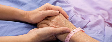 Two people holding hands; providing a retiree health care.